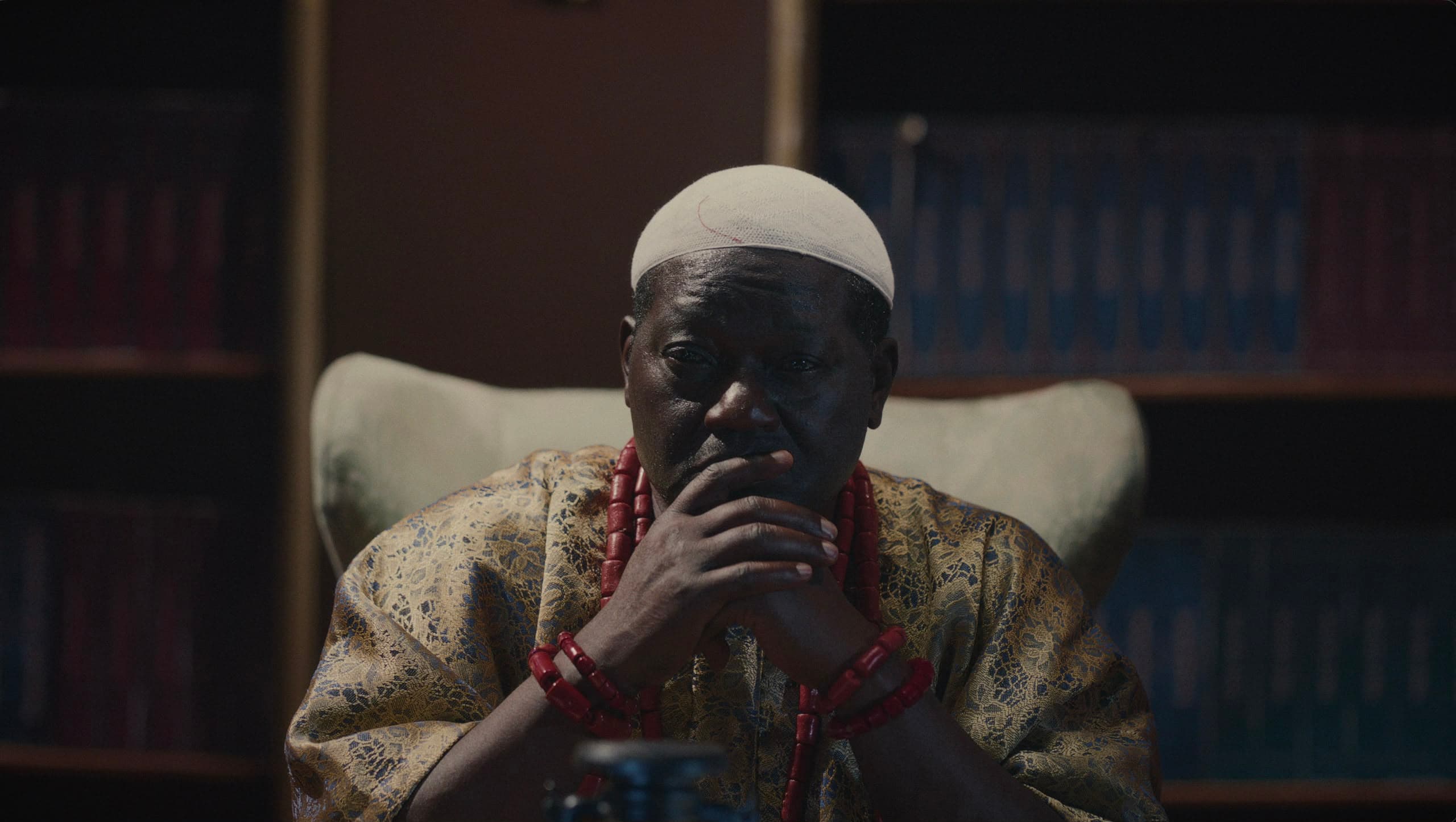 Still from Agbáraǹlá: The Return — The chief weighs it